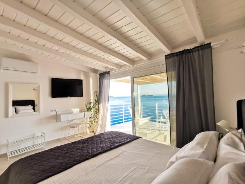 a bedroom with a bed and a view of the ocean at Evgenia Seafront House in Skiathos Town