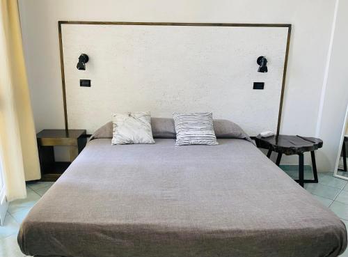 a bed in a room with two pillows on it at Black Market Hotel in Ischia