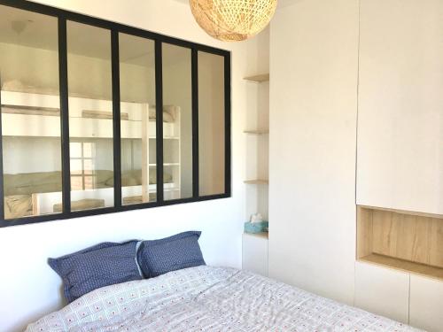 迪耶普Bel appartement vue mer centre-ville, face plage的卧室里有一张床，墙上有一面镜子