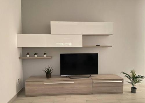 ein Wohnzimmer mit einem Flachbildfernseher auf einem Schrank in der Unterkunft Shining house in Milan in Mailand