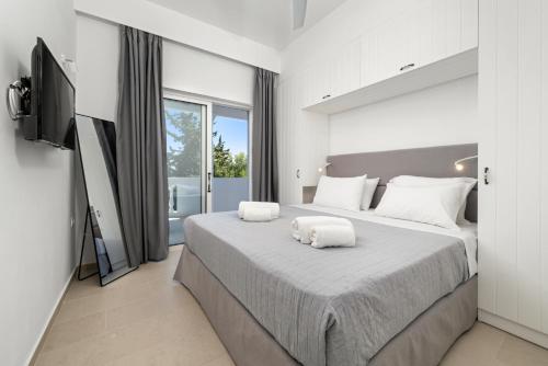 a bedroom with a large bed with two towels on it at Playia Villas I in Petrití