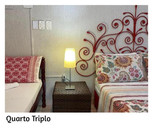 1 dormitorio con 1 cama y 1 lámpara en una mesa en Pousada Porto Búzios en Búzios