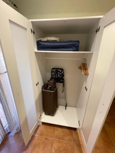 a walk in closet with white cabinets and a suitcase at Apartamento vacacional in El Pont de Suert