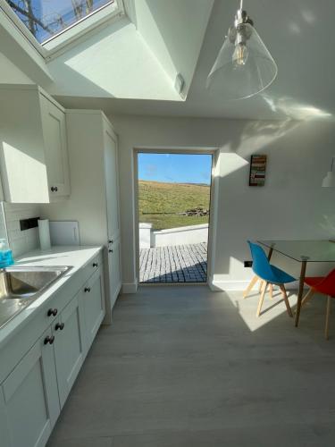 a kitchen with a table and a view of the ocean at Kathleen's Carrowkeel Cottage in Sligo