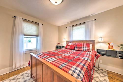 a bedroom with a bed with a plaid bedspread and two windows at Lucky Dawg Pet-Friendly Abode Near St Louis! in Pacific