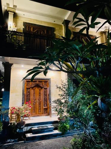 a house with a wooden door and some plants at Wina Ubud B&B in Ubud