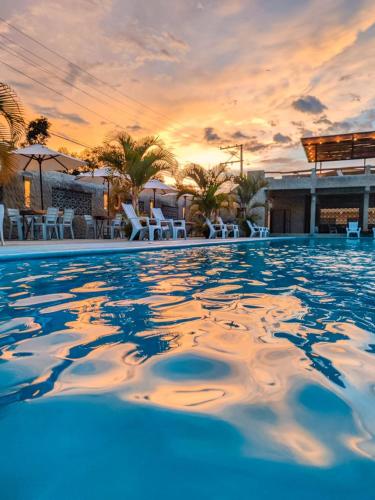 a pool at a resort with a sunset in the background at Lindo apartamento vacacional en guaduas in Guaduas