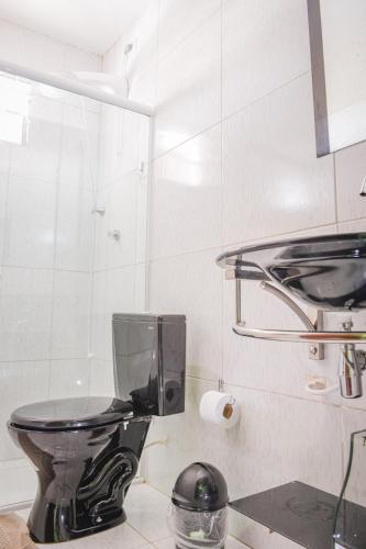 a bathroom with a black toilet in a room at Pousada Passarela do Caranguejo PB in Conde