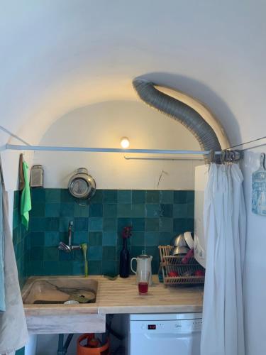 a kitchen with a sink and green tiles at Ilha ALFRIDA in Carrapatelo