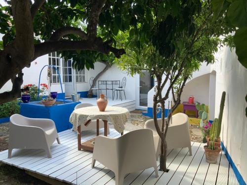 a patio with a table and chairs under a tree at Ilha ALFRIDA in Carrapatelo
