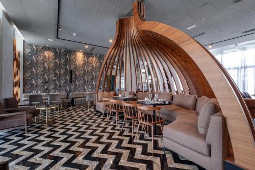 a restaurant with a couch and tables and chairs at Occidental Tanger in Tangier