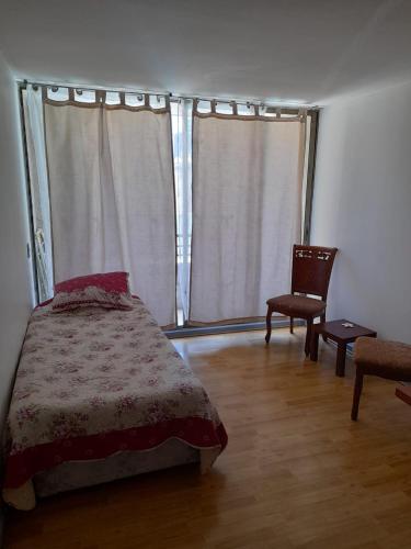 a bedroom with a bed and a chair and a window at Turismos brisa in Santiago