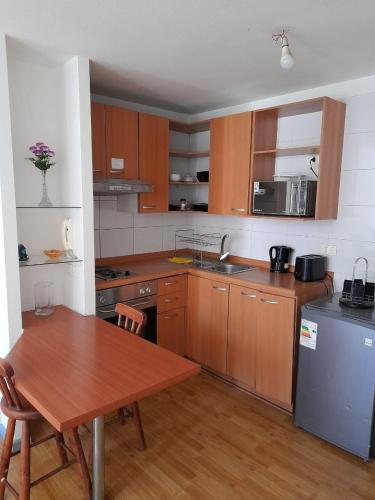 a kitchen with wooden cabinets and a wooden table and a table and a tablektop at Turismos brisa in Santiago
