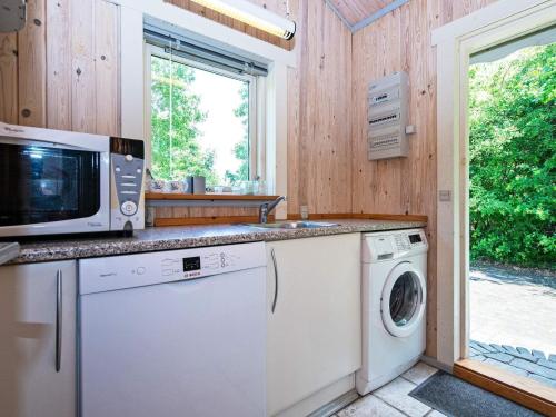 a kitchen with a microwave and a washer and dryer at 6 person holiday home in Silkeborg in Silkeborg