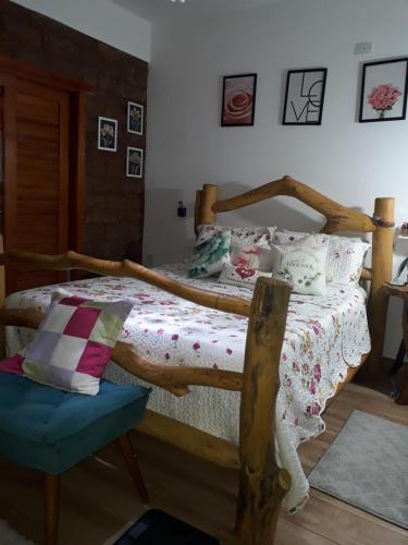 a bedroom with a wooden bed and a chair at Casa dos Sonhos Hospedaria in Sêrro