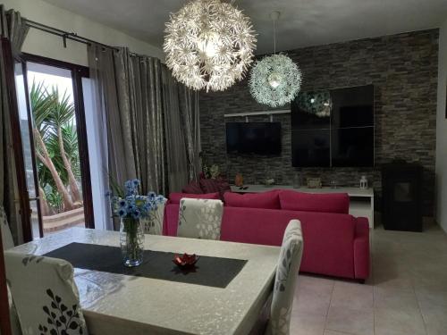 a living room with a pink couch and a table at Casa vacanza Maligio' Nebida Masua in Nebida