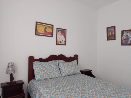 a bedroom with a bed and pictures on the wall at DUNAS BEACH - (Praia de Dunas e Forte) - Arejado e luminoso com amplo espaço esterno e churrasqueira. in Cabo Frio