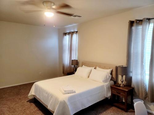 a bedroom with a white bed with a ceiling fan at Phoenix Comfort home II in Phoenix