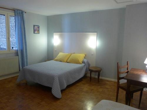 Un dormitorio con una cama con almohadas amarillas y una mesa. en Gîte Aubepierre-sur-Aube, 3 pièces, 5 personnes - FR-1-611-52, 