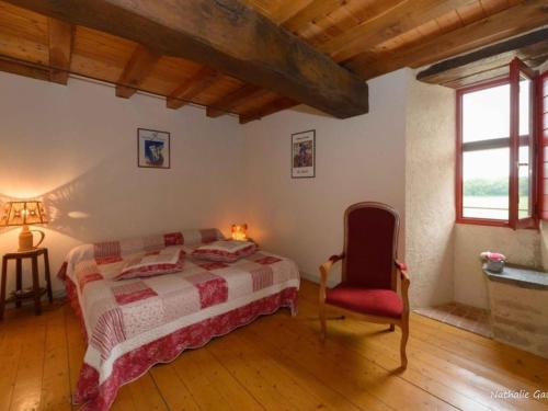 1 dormitorio con 1 cama y 1 silla roja en Gîte Pannecé, 5 pièces, 8 personnes - FR-1-306-1114, en Pannecé