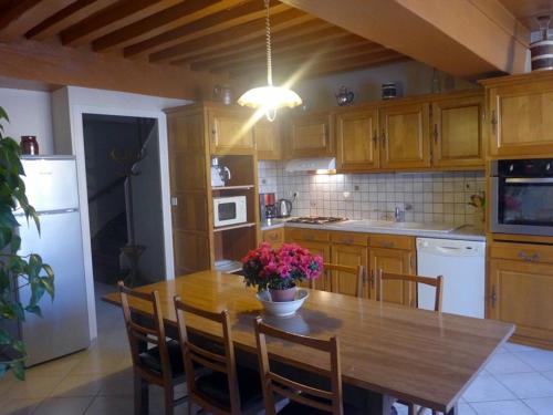 una cocina con una mesa de madera con flores. en Gîte Aubepierre-sur-Aube, 5 pièces, 9 personnes - FR-1-611-1, 