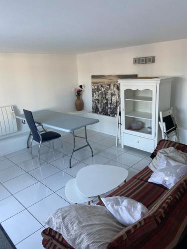 sala de estar con mesa y sofá en Bel appartement chez particulier calme et piscine, en Royan