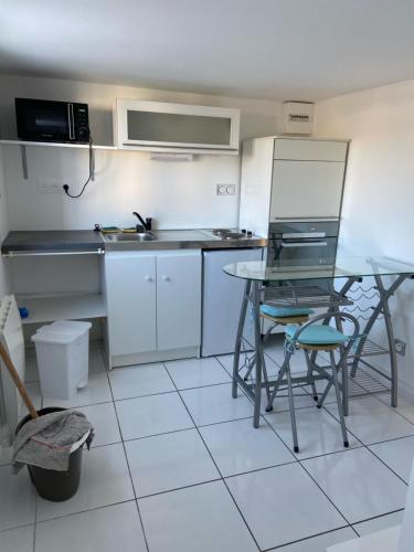 - une cuisine avec une table, une table et des chaises dans l'établissement Bel appartement chez particulier calme et piscine, à Royan
