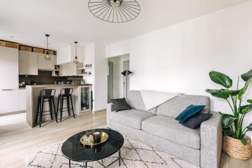 a living room with a couch and a table at GuestReady - Charming Apartment on the top floor in Paris