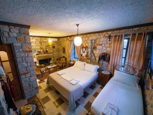 a bedroom with two beds and a stone wall at Solomon&Sons in Dhërmi