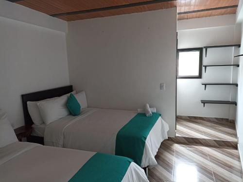1 dormitorio con 2 camas y ventana en Hotel SAMAI, en San Agustín