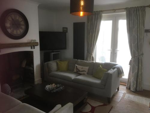 a living room with a couch and a tv at Rose Cottage, Newbiggin-by-the-Sea in Woodhorn