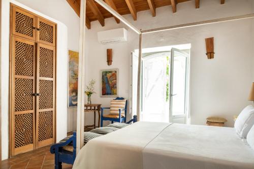 a bedroom with a white bed and a door at Altanure - Quinta Sol d'Agua Beautiful Country Side Cottage with Private Pool in Tavira