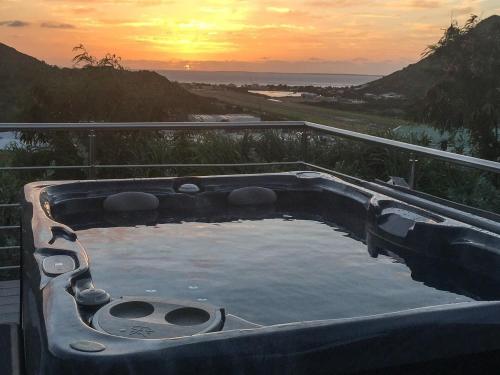 a hot tub with the sunset in the background at The Rock in Cul de Sac
