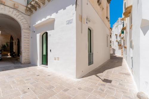 an alley with white walls and an archway at Relais La Casa del Poeta in Gallipoli