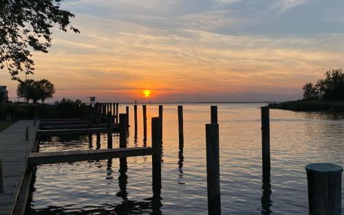 a sunset over a body of water with a dock at Tilghman Island Inn in Tilghman Island