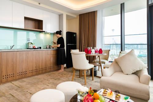 a woman standing in the kitchen of a apartment at Muong Thanh Luxury Ha Long Centre II in Ha Long