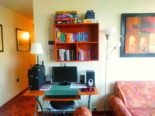 um quarto com uma secretária com um computador e uma estante de livros em Lima Backpackers em Lima