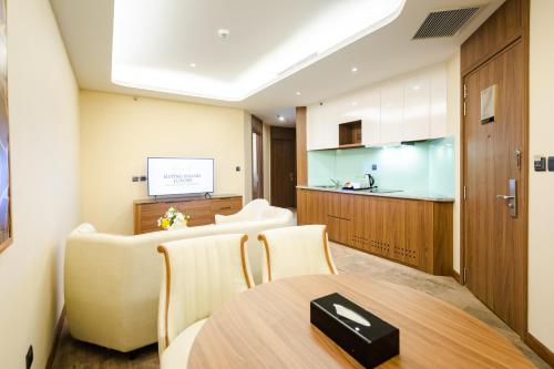 a room with a table and chairs and a kitchen at Muong Thanh Luxury Ha Long Centre II in Ha Long