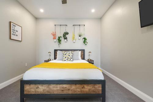 a bedroom with a bed with yellow and white sheets at HostWise Stays - Free Parking Downtown - Skyline Views in Pittsburgh