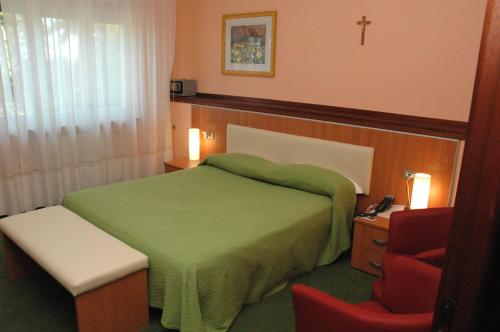 a bedroom with a green bed and a red chair at Hotel Da Angela in Sedegliano