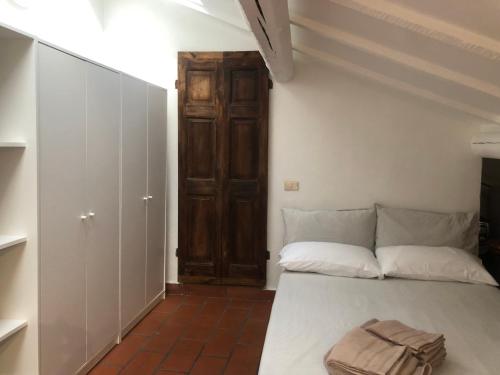 Cette chambre dispose d'un lit avec une porte en bois. dans l'établissement Il tetto fiorito dell'Isola, à Milan