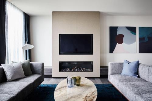 a living room with two couches and a fireplace at Hyatt Place Melbourne Caribbean Park in Scoresby