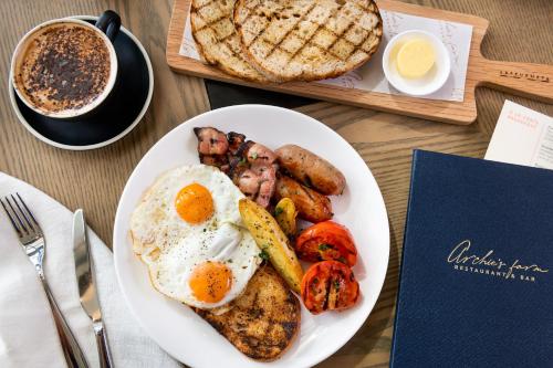 a plate of breakfast food with eggs and potatoes and a cup of coffee at Hyatt Place Melbourne Caribbean Park in Scoresby