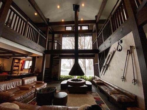 a large living room with a couch and a table at Alp Bach Madarao in Iiyama