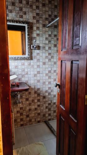 a bathroom with a shower with a sink and a door at Hostel Lagoa do Sol in Saquarema