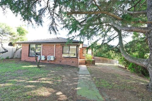 a brick house with a tree in front of it at Best Location Entire House Staycation Parkland Surrounding in Hallam