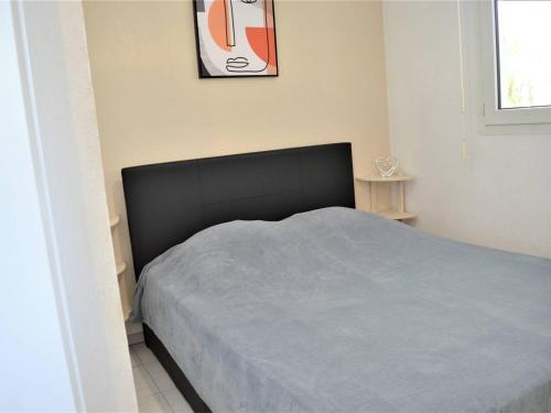 a bedroom with a bed with a black head board at Appartement T2 avec Terrasse et Garage en Plein Centre, 4 Couchages - Cavalaire-sur-Mer - FR-1-226B-105 in Cavalaire-sur-Mer