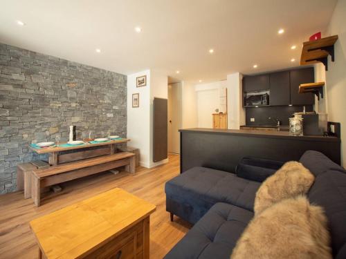 un salon avec un canapé bleu et une cuisine dans l'établissement Charmant 2 pièces pour 5 pers avec balcon, service linge inclus ! - FR-1-291-877, à Valmorel