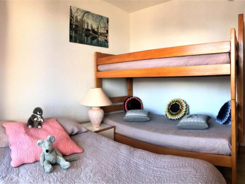 - une chambre avec 2 lits superposés et un ours en peluche dans l'établissement Appartement rénové au pied des pistes avec 2 balcons, piscine et WiFi - FR-1-267-198, au Corbier