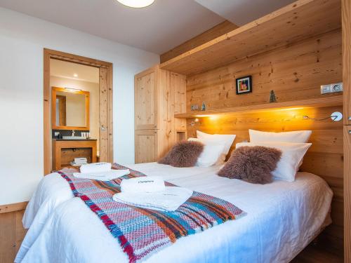 - une chambre avec un grand lit blanc et des murs en bois dans l'établissement Chalet Landenoire · Ski-in/Ski-out · Sauna & Jacuzzi · Parking · WiFi · 8 Pers. - FR-1-344-777, à Saint-Martin-de-Belleville